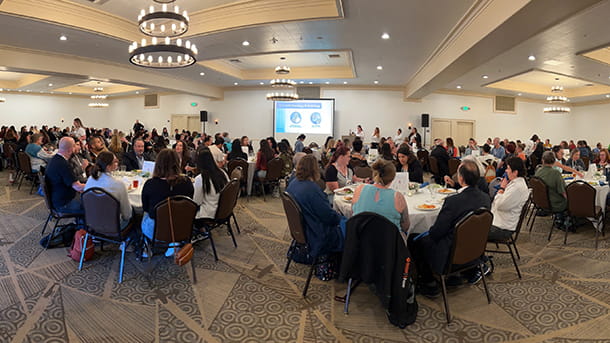 Groups of people sitting at tables during a learning event