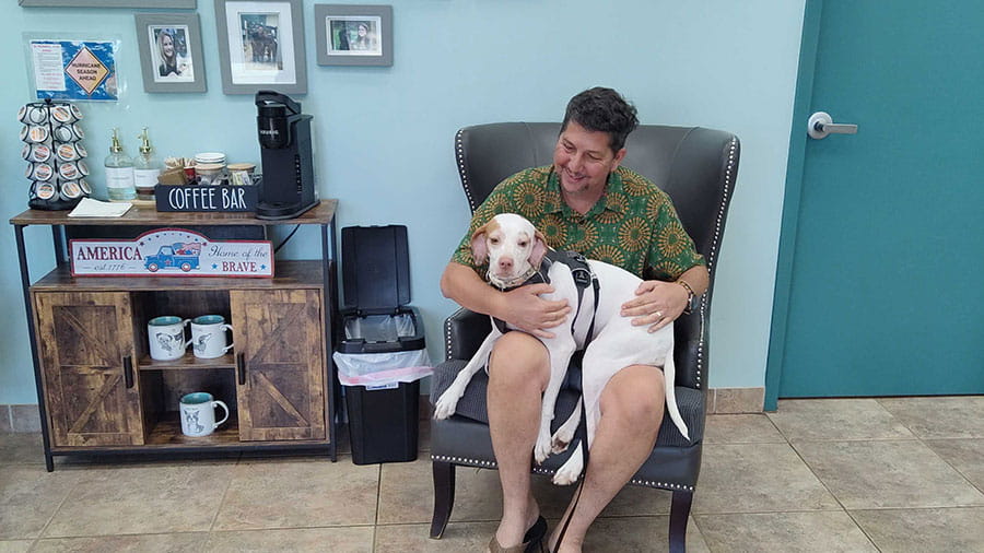 Man holding dog in lobby at VCA Miracle Mile Animal Hospital